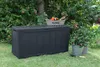 A dark grey Keter garden box is placed on a green lawn in a garden setting, surrounded by plants and trees. Anteprima dell’immagine prodotto