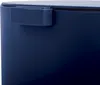 A close-up view of the top corner of a dark blue trash can, showing a part of the lid and a hinge mechanism. Náhľad obrázku produktu