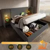 A modern upholstered bed with storage, featuring integrated bedside tables with charging capabilities and a reading lamp. Náhled obrázku produktu