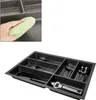 A hand is cleaning a drawer organizer with a green cloth. The organizer is filled with cutlery. Produktbild-Vorschau