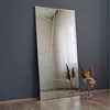 A full-length mirror with a geometric design, leaning against a dark gray wall. Two vases with dried flowers are placed on the floor in front of the mirror. Náhled obrázku produktu