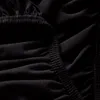 A close-up view of black fabric with elastic gathering. Produktbild-Vorschau