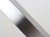 A close-up, abstract shot of a brushed metal table leg or frame against a plain white background. Náhled obrázku produktu