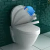 A toilet seat is shown in a bathroom setting with a blue arrow indicating it is soft closing. Produktbild-Vorschau