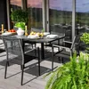 An outdoor dining set on a wooden deck with a lush green plant in the foreground. Náhled obrázku produktu
