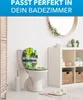 A bathroom scene featuring a toilet with a decorative seat and lid, a shelf unit with storage baskets and decorative items, and a wooden screen. Produktbild-Vorschau