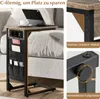 A C-shaped side table with integrated charging ports and storage pockets, placed next to a sofa. Produktbild-Vorschau
