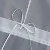 A close-up view of a white ribbon tied in a bow on a gray fabric. Produktbild-Vorschau