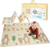 A baby is playing on a folded foam play mat with animal and tree designs. The mat is partially folded, showing its flexibility. A yellow carrying case for the mat is also visible in the background. Náhľad obrázku produktu