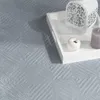 A close-up view of a textured blue rug with a white tray containing decorative items placed on it. Anteprima dell’immagine prodotto