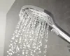 A close-up shot of a chrome and white hand shower head with water spraying from it. Anteprima dell’immagine prodotto