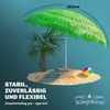 A beach scene with a palm tree and a large green umbrella. Produktbild-Vorschau