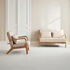 A minimalist living room scene with a wooden armchair and a two-seater sofa. Anteprima dell’immagine prodotto