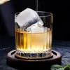 A close-up shot of a glass of whiskey with a large ice cube, being poured into it. Náhled obrázku produktu