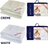 A collage showing two different colored duvets (cream and white) and their packaging. Voir les images du produit