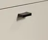 A close-up shot of a black drawer pull on a light-colored cabinet. Voir les images du produit