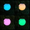 Four different colored LED light orbs hanging in a garden setting at night. Produktbild-Vorschau