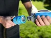 A person is connecting two parts of a garden hose in an outdoor setting. Voir les images du produit