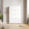 A white modular storage unit is shown against a light gray wall, with a handbag hanging on its side. The floor is light wood, and a rug is partially visible in the foreground. A window is on the left, and a curtain is on the right. Voir les images du produit