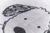 A close-up view of a printed pattern on a light gray fabric. Produktbild-Vorschau