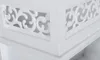 A close-up view of a white decorative element with intricate cut-out patterns. Náhled obrázku produktu