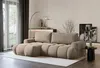 A modern living room with a sectional sofa, floor lamp, and decorative items. Voir les images du produit