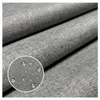 A close-up view of grey fabric with water droplets on it, indicating water resistance. Produktbild-Vorschau