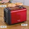 A red Bosch toaster with two bagels on top, placed on a wooden table. Voir les images du produit