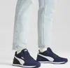 A person wearing blue jeans and blue Puma sneakers. Anteprima dell’immagine prodotto