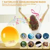 A woman stretching with music notes emanating from a sunrise alarm clock. Produktbild-Vorschau