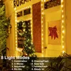 A decorated storefront with Christmas lights and a small Christmas tree. Produktbild-Vorschau