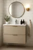A modern bathroom vanity with a round mirror above it. Produktbild-Vorschau