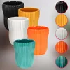 A collection of five ceramic pots in different colors, arranged in a staggered formation. To the right, there are circular close-ups of each pot's texture and color. Voir les images du produit