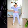 A woman is exercising with a hula hoop in a bright, modern room. Podgląd zdjęcia produktu