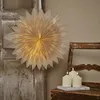 A paper star lantern is displayed on a rustic wooden door, with three white pillar candles on a wooden chair in the foreground. Podgląd zdjęcia produktu