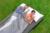 A couple sleeping on an air mattress outdoors on the grass. Náhled obrázku produktu