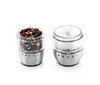 Two spice grinders, one filled with peppercorns and the other with coarse salt, are displayed against a white background. Anteprima dell’immagine prodotto