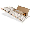A wooden bed frame with adjustable slats and a box of assembly parts.