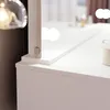 A close-up view of a white vanity table with a mirror and some decorative items. Náhled obrázku produktu