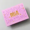 A pink birthday card with the name MIA cut out and gold foil showing through, surrounded by birthday-themed illustrations. Produktbild-Vorschau