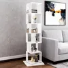 A white, multi-level rotating bookshelf is placed in a living room setting next to a gray sofa and a piece of abstract art on the wall. Produktbild-Vorschau