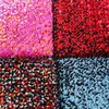 A close-up view of a patchwork rug with four distinct colored squares. Produktbild-Vorschau