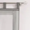 A close-up view of a gray sheer curtain with tab loops hanging from a curtain rod. Produktbild-Vorschau