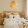 A bedroom scene with a bed, pillows, and a hanging lamp. Náhled obrázku produktu