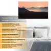 A marketing image for a Heidenfeld infrared heater, showing a landscape image on the heater and a bed with pillows in the background. Produktbild-Vorschau