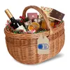 A wicker picnic basket filled with festive items, including a bottle of wine, chocolates, dried oranges, pinecones, and a jar of honey. Produktbild-Vorschau