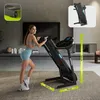 A woman is using a treadmill in a modern living room. Podgląd zdjęcia produktu