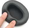 A close-up of a black headphone earpad with fingers pressing on it. Produktbild-Vorschau