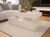 A modern living room scene featuring a white coffee table with LED lighting, a sectional sofa, and a fireplace. Náhled obrázku produktu