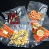 Various vacuum-sealed food items including steak, shrimp, salmon, carrots, and tortellini, arranged on a black background. Produktbild-Vorschau